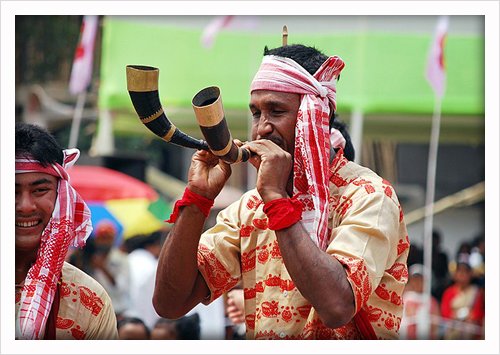A Bihu dancer playing the traditional "Pepa"